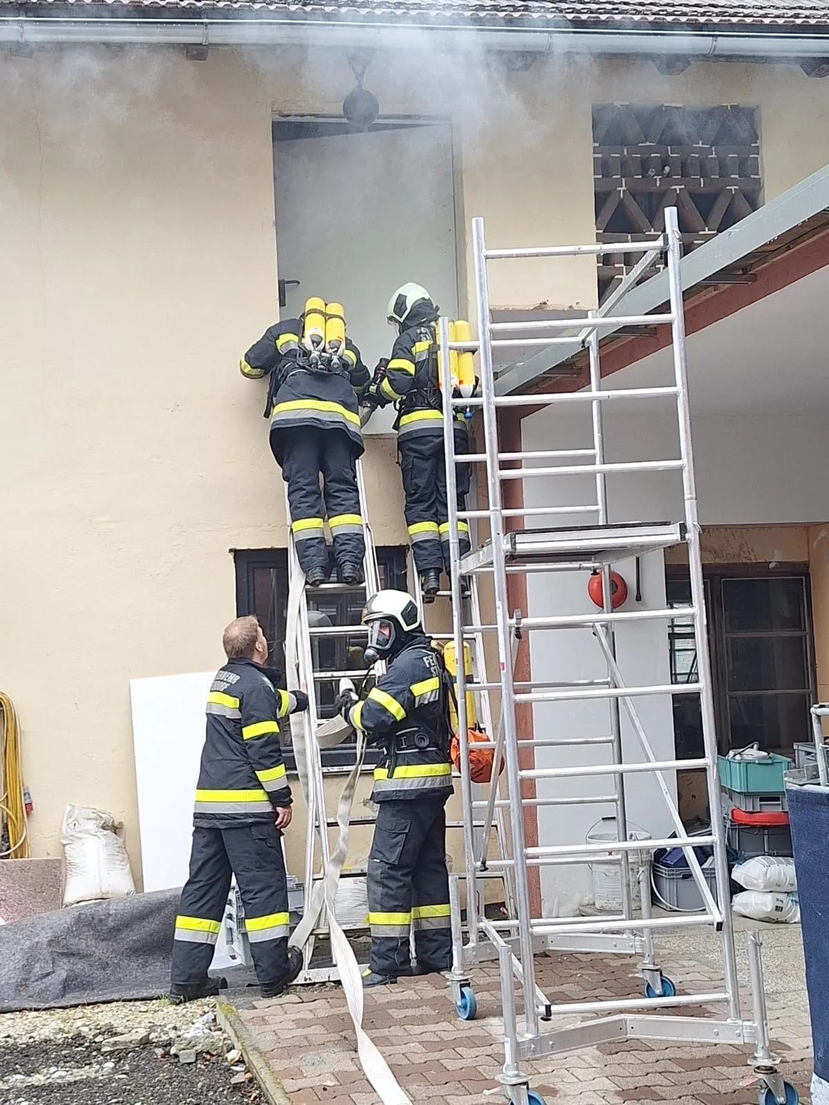 Feuerwehrleute auf einem Steiger im dichten Rauch während einer Übung
